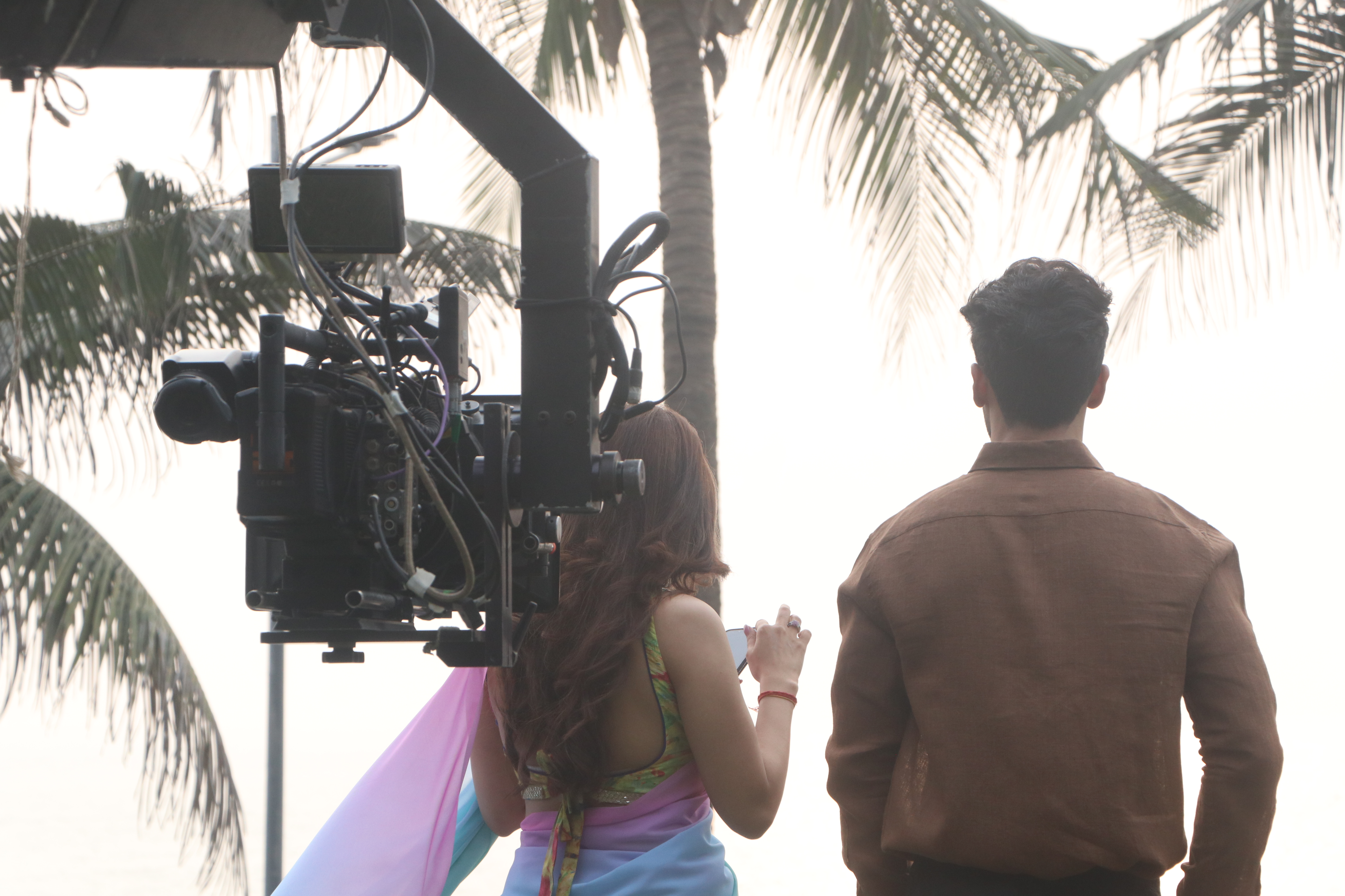 Gimbal operator following talent during a golden-hour beach shoot