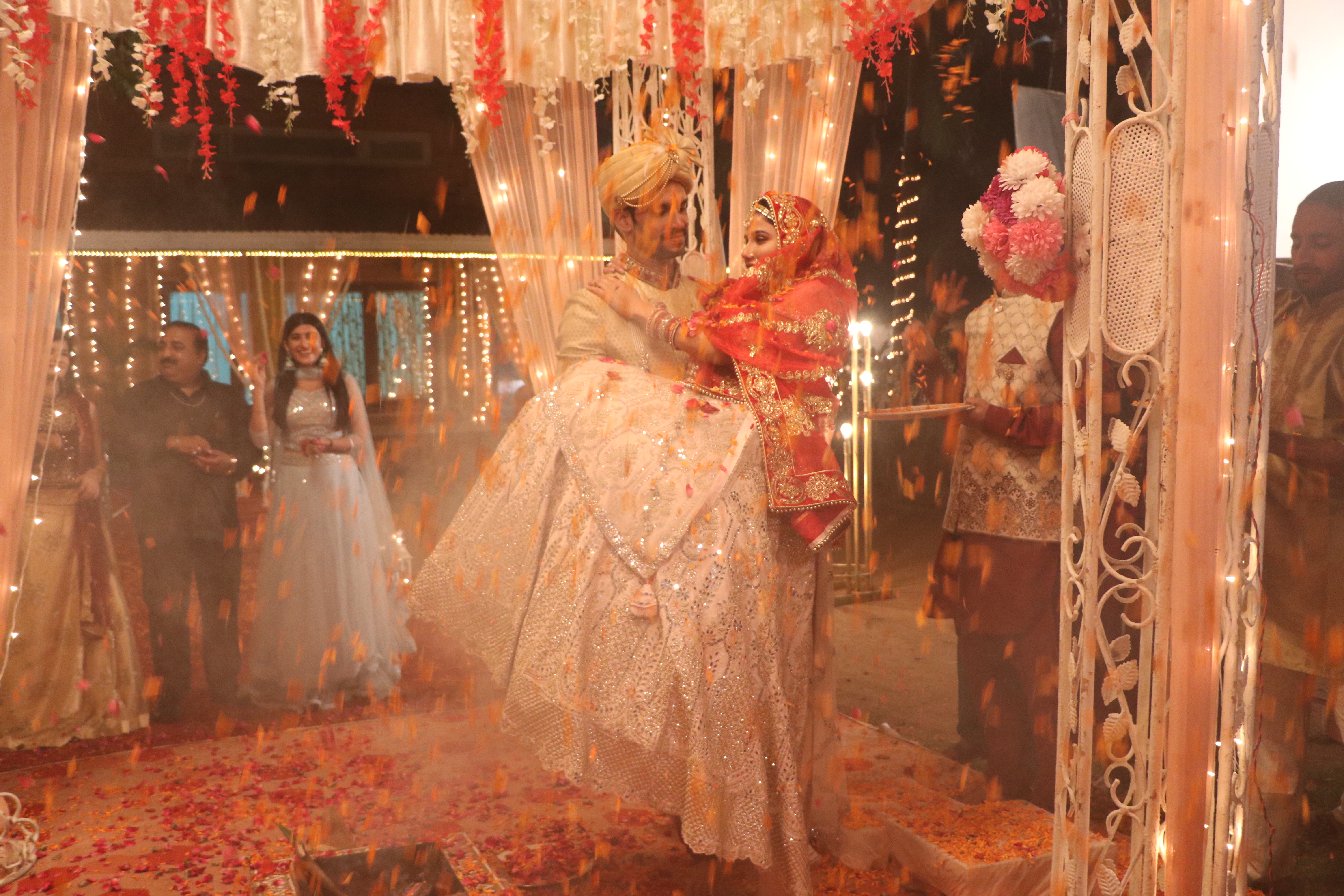 Wedding scene with flower petals raining under warm lights